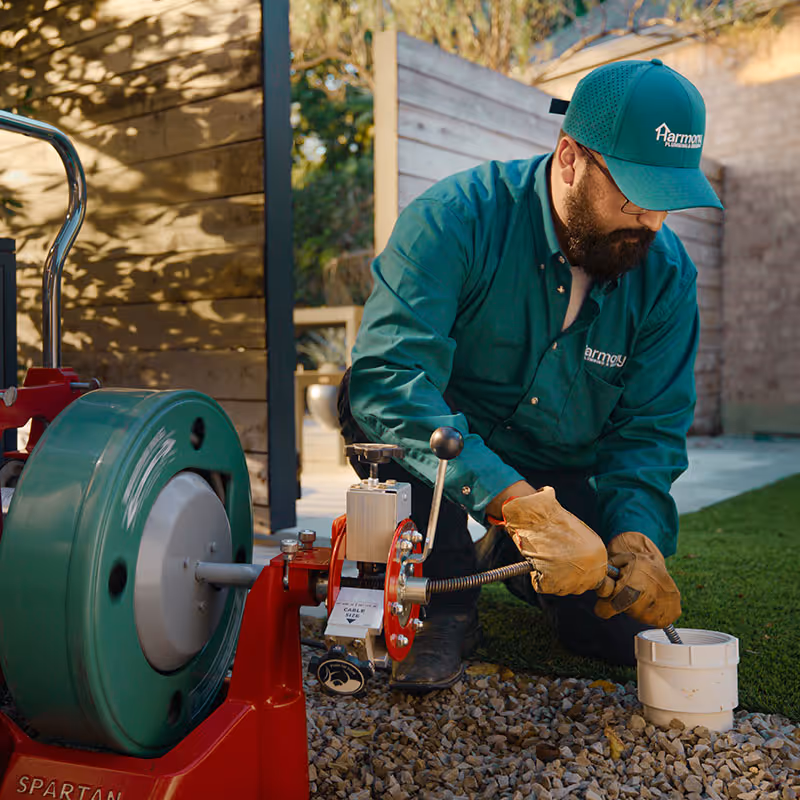A Plano, TX plumber using a wrench to fix a pipe