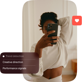 Person in white raised arm and holding phone for selfie with digital text on trend detection and performance.