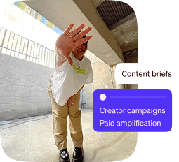 Man smiling and waving under a concrete overpass with digital text graphics.