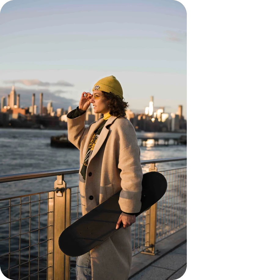 Content creator on the Brooklyn waterfront with the Manhattan skyline behind her