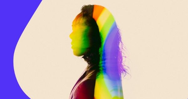 A woman with a red shirt and black hair is shown in a rainbow colored background.