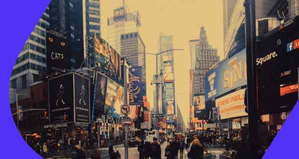 A busy city street with people walking and a street sign that says "One Way".