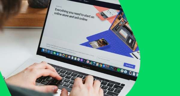 A person is typing on a laptop with a website open.