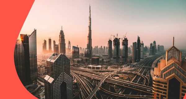 A cityscape with a tall building and a highway.