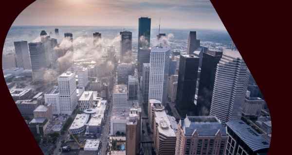 A city skyline with a large building and a street.