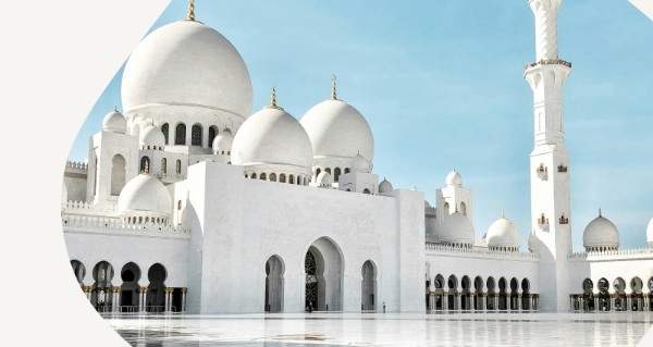 A white building with a gold roof and a blue sky.