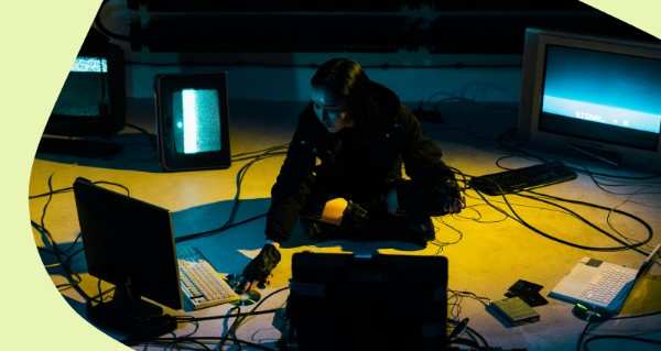 A woman sitting on the floor in front of a computer.