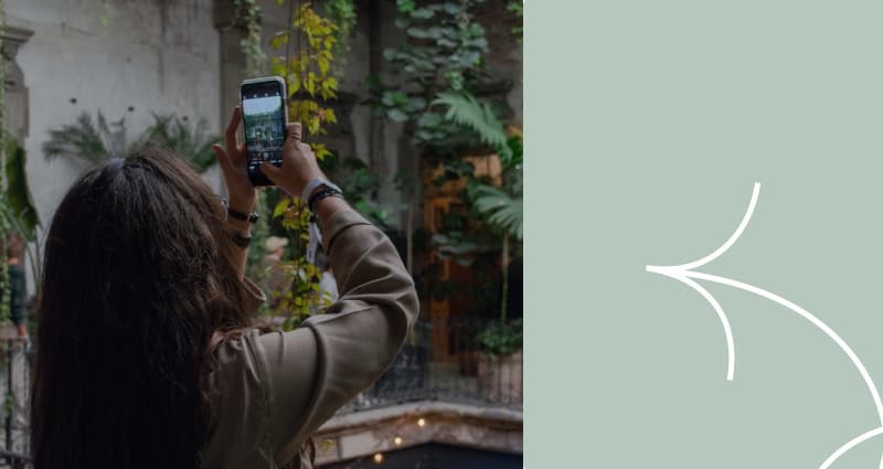 A woman taking a picture of a cell phone.