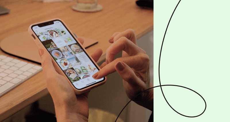 A person holding a cell phone with a picture of food on the screen.