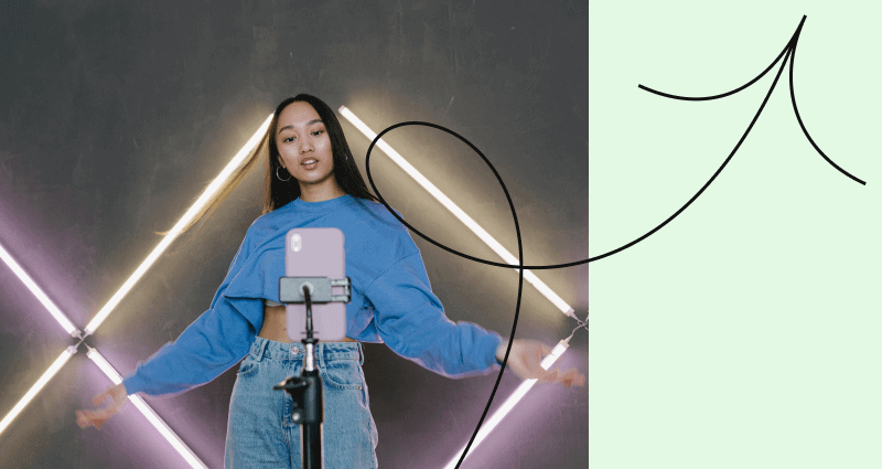 A woman with a cell phone in front of a triangular light.