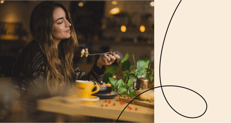 A woman eating a salad with a fork.