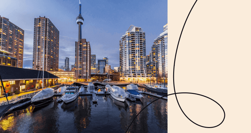 A city skyline with a large building and a boat in the water.