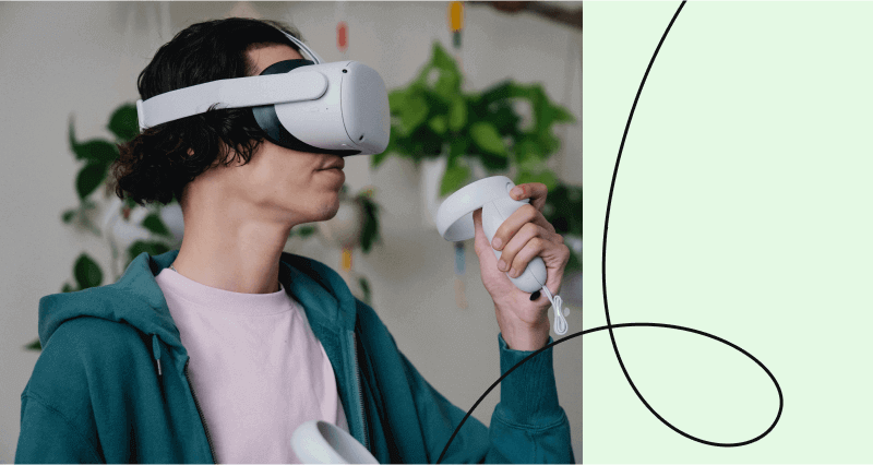 A man wearing a blue jacket and holding a white remote.