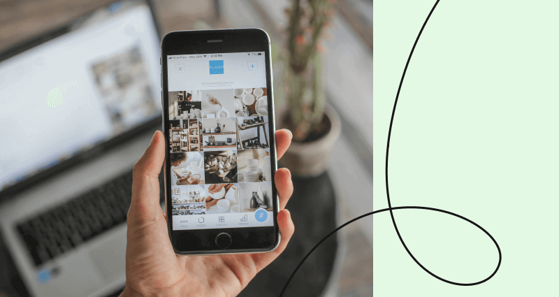 A person holding a cell phone with a picture of a potted plant on it.