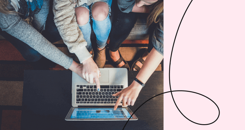 A laptop with a woman pointing at it.