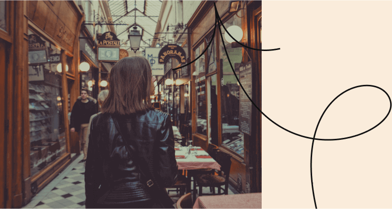 A woman in a black leather jacket standing in front of a restaurant.