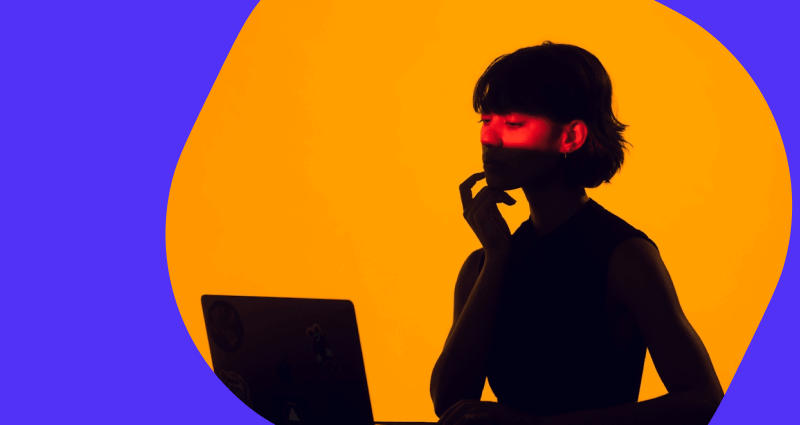 A woman is sitting in front of a laptop computer.