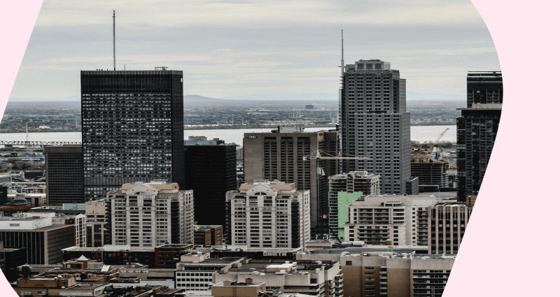 A cityscape with a large building and a crane in the distance.