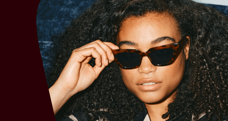 A woman with sunglasses and a black shirt.