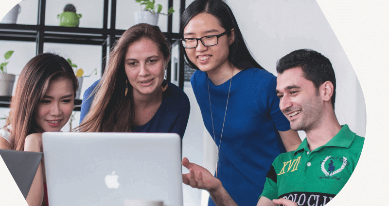 Three people looking at a laptop screen.