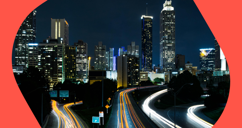 A city street at night with a blurry image of a highway.