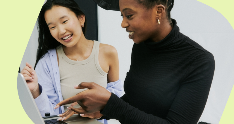 Two women are looking at a laptop screen.