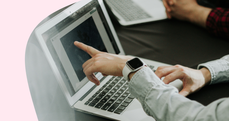 A person is using a laptop with a watch on their wrist.