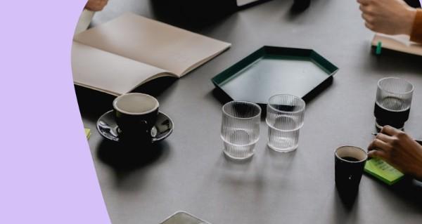 A table with a cup of coffee and a book.