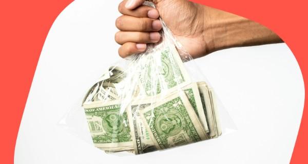 A hand holding a bag of money.