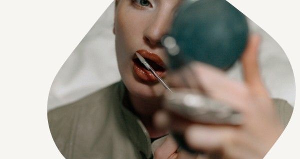 A woman brushing her teeth in front of a mirror.