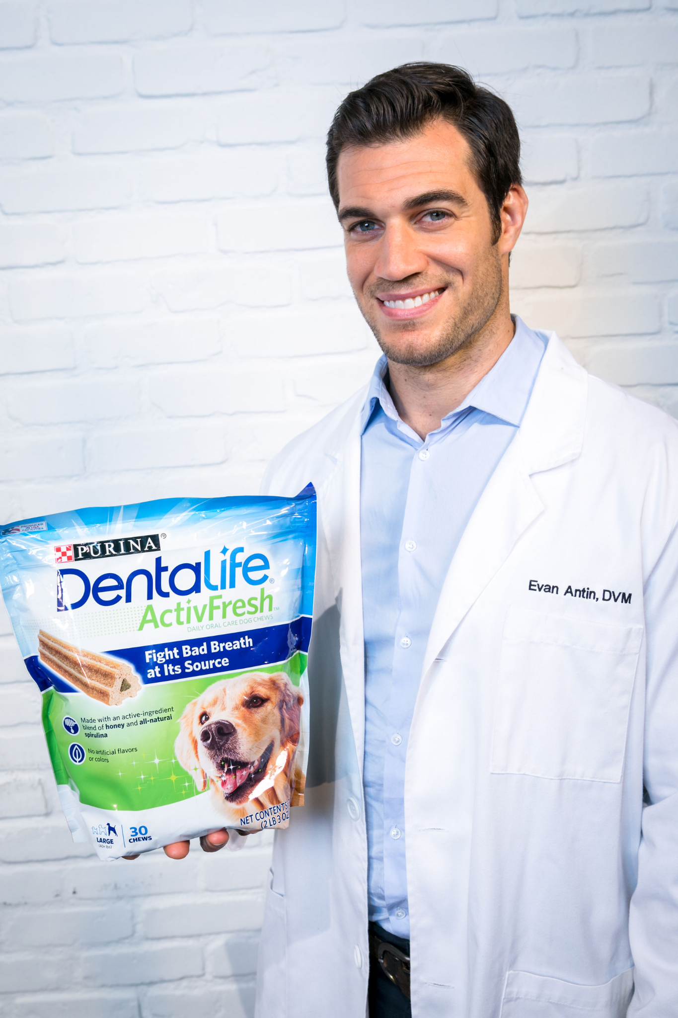 Veterinarian Dr. Evan Antin holding a Purina DentaLife ActivFresh dog dental chew package