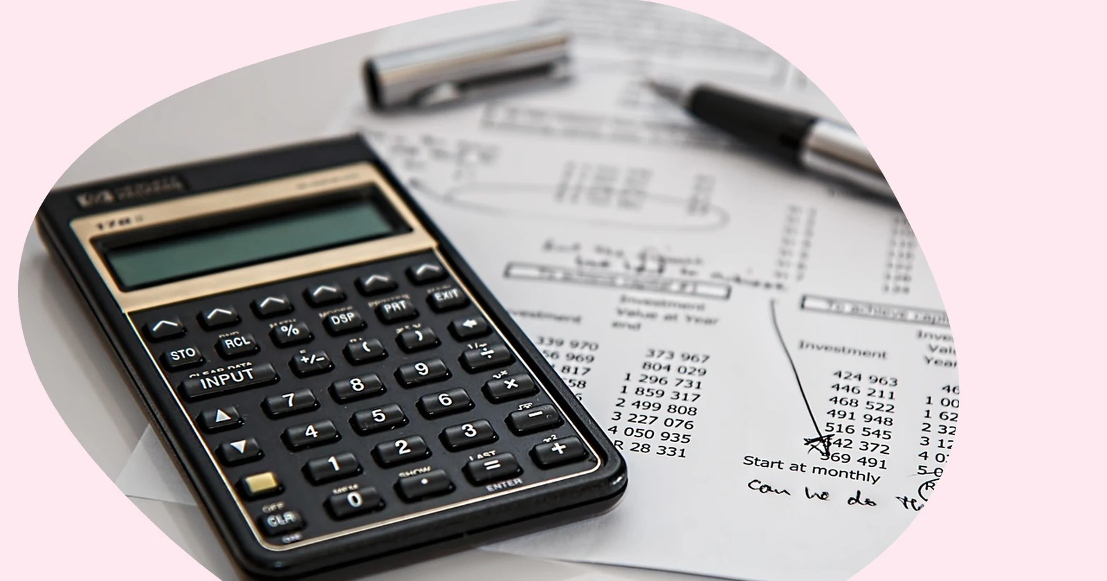 Calculator and a printed financial spreadsheet on a desk with a pen