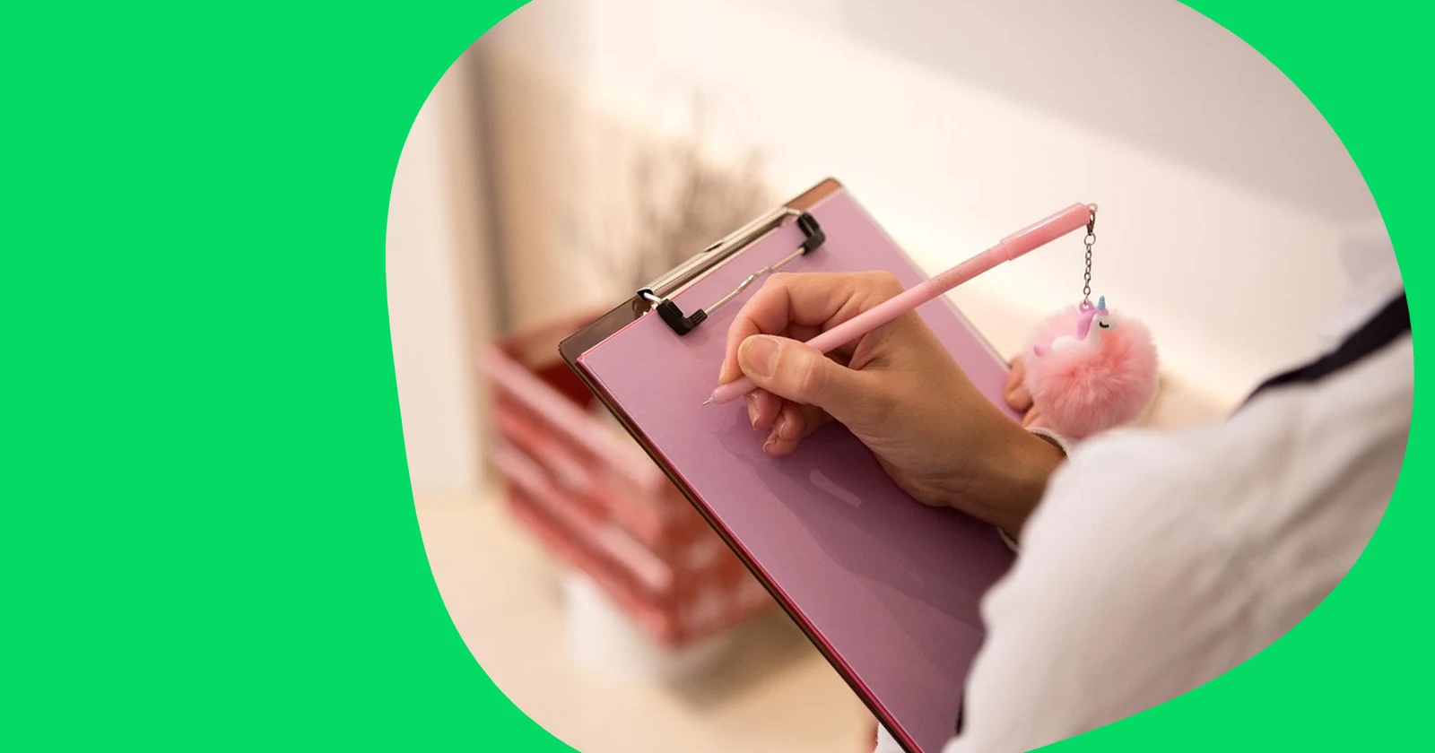 Person writing on a pink clipboard with a pen
