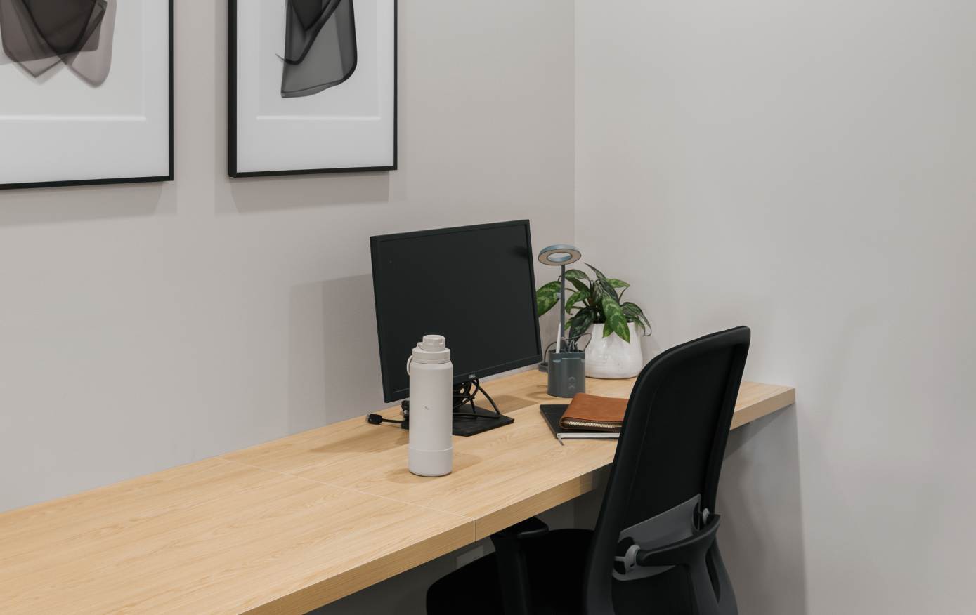A single desk with a monitor and an ergonomic chair