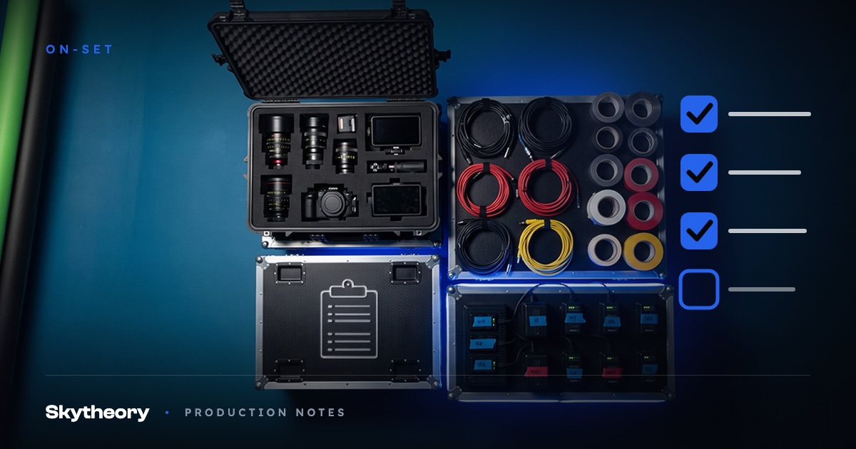 Overhead view of organized road cases with lenses, coiled cables, gaffer tape, and labeled batteries staged for a studio shoot day