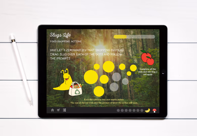 Tablet on a white desk displaying a 'Slugs Life' zero waste shopping game with yellow dots, a cartoon slug holding a recycling bag, and prompts against a forest background.