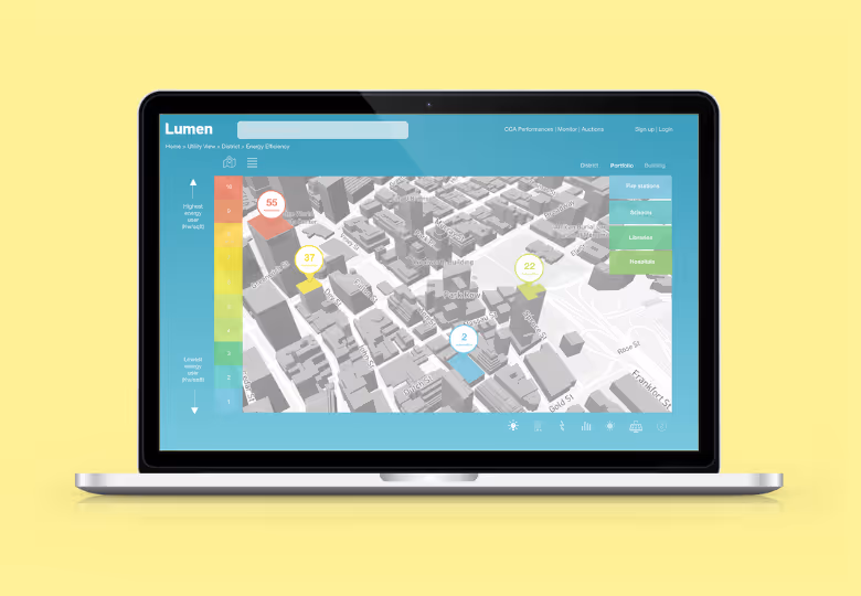 Laptop displaying a 3D city map with energy efficiency data points and a color-coded scale from highest to lowest energy use.