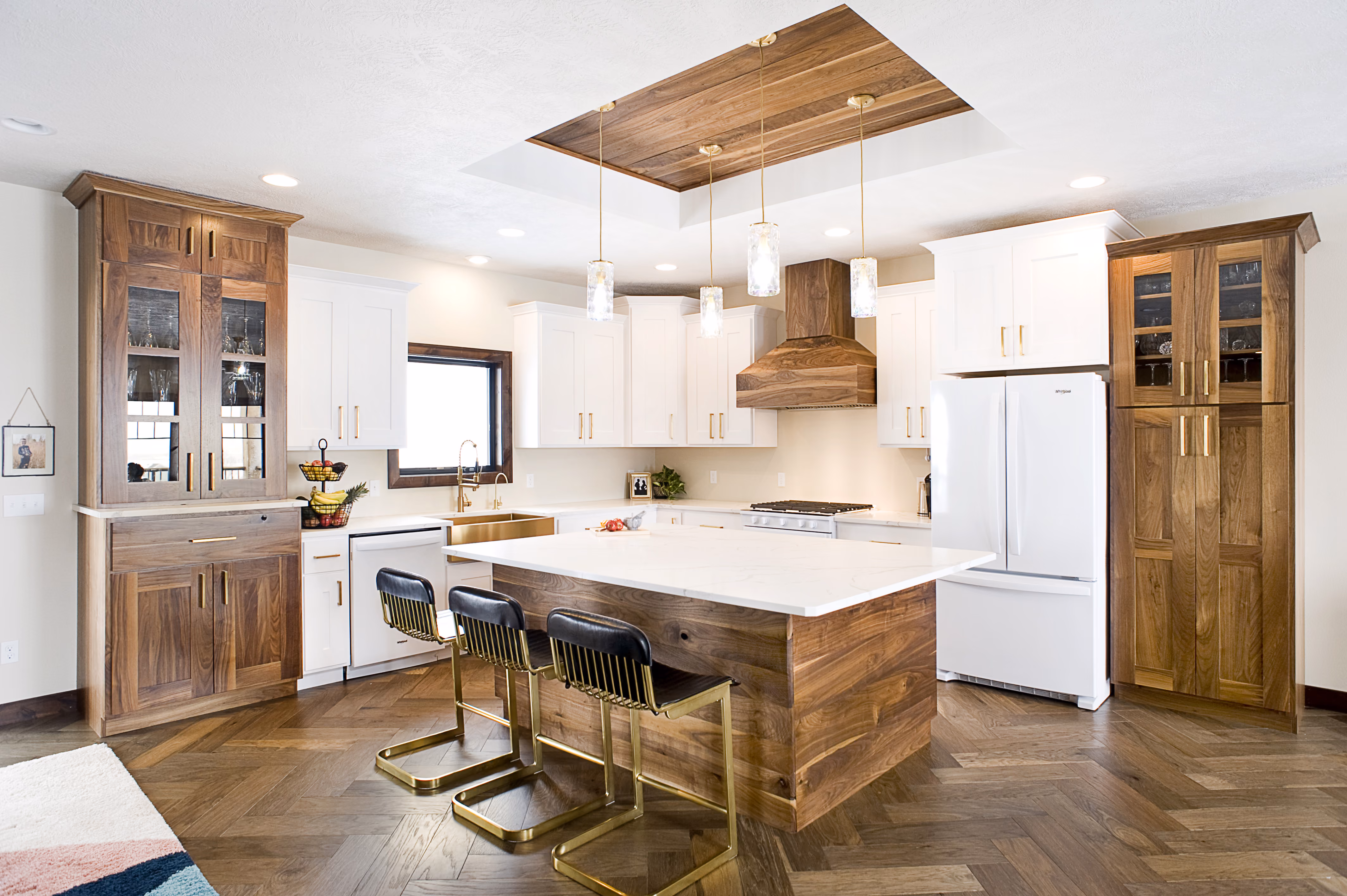 A custom kitchen with white and walnut cabinets built by OdeCo in a new custom home in Brandon, SD.