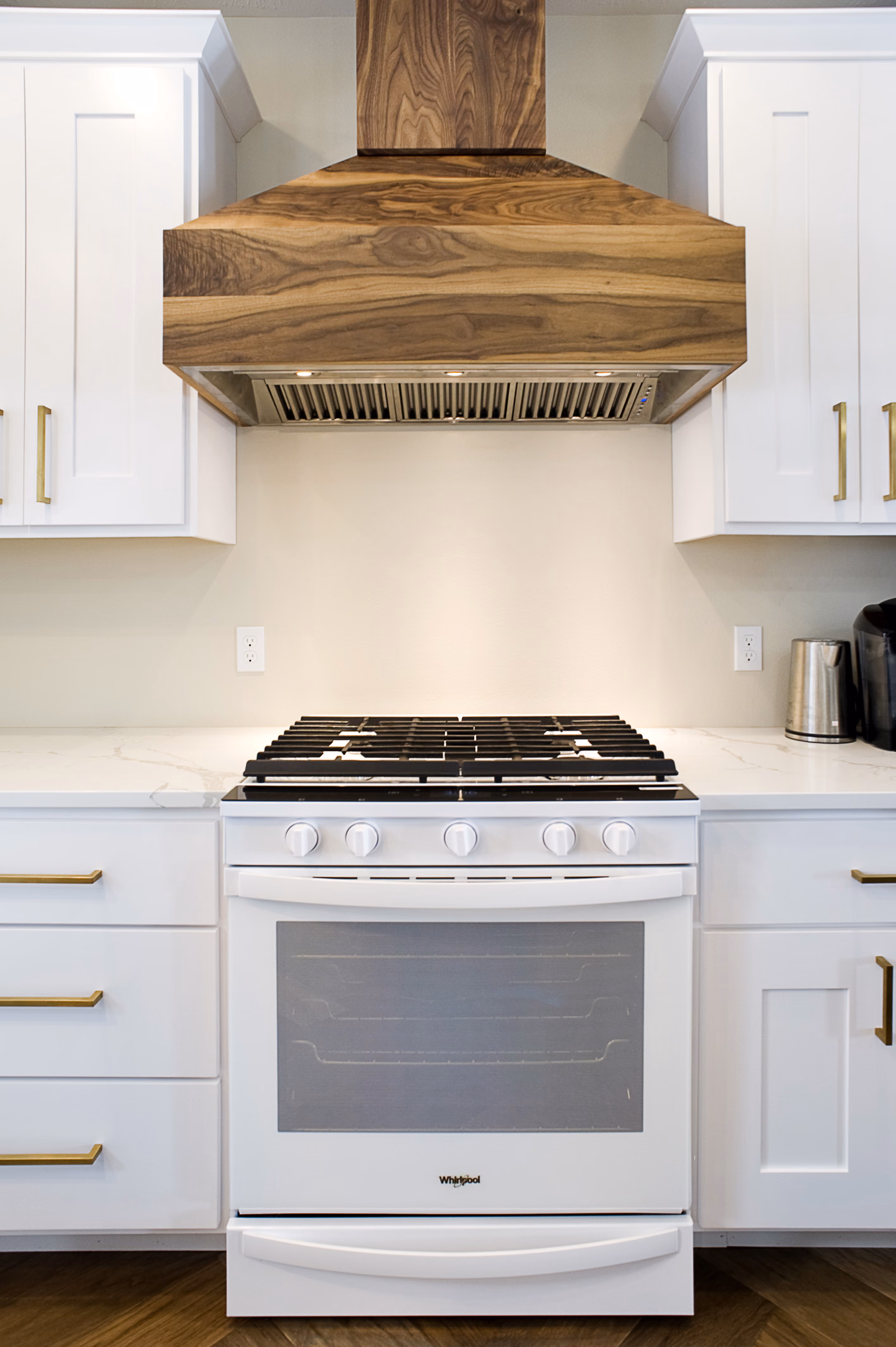 A stove with a custom walnut hood installed above it by OdeCo in Brandon, SD.