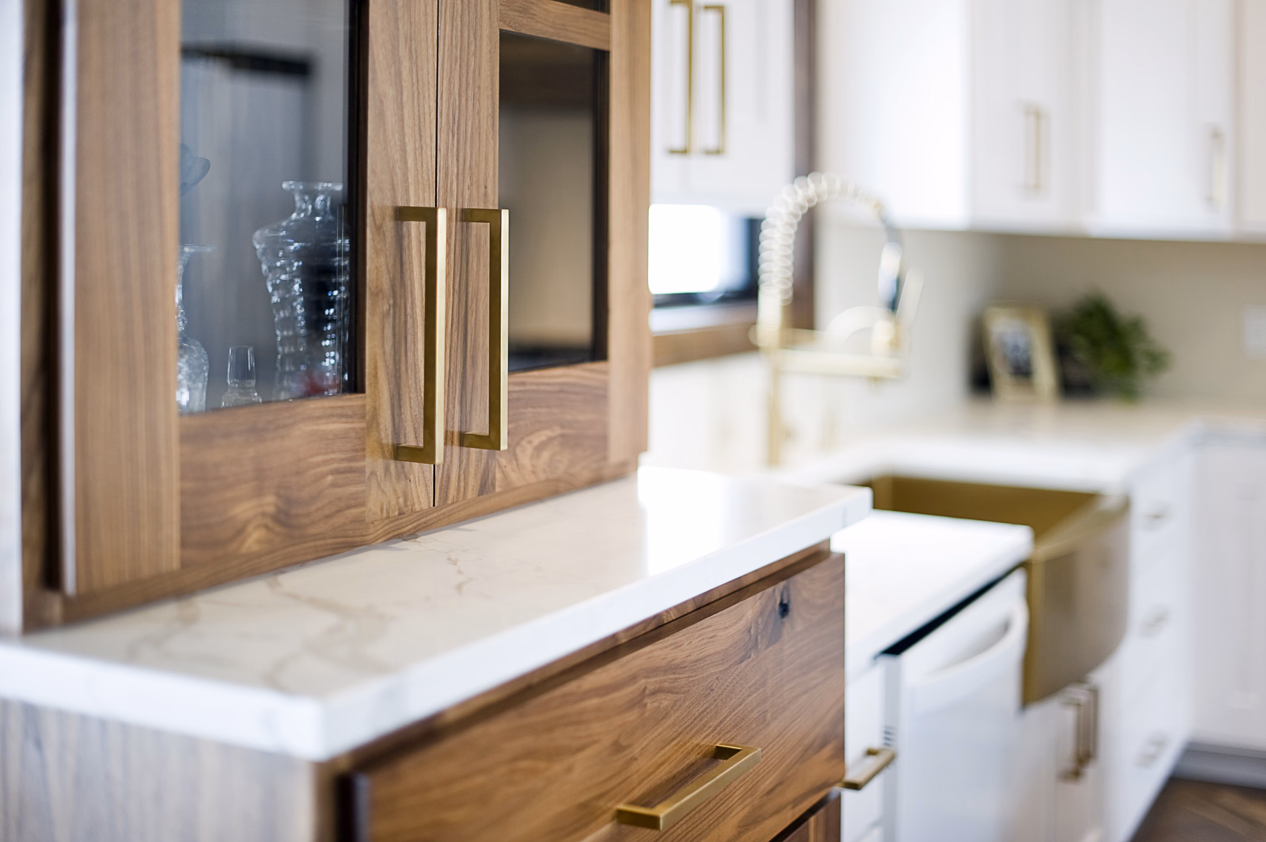 A custom walnut cabinet with white counters installed in a new home by OdeCo in Branon, SD.