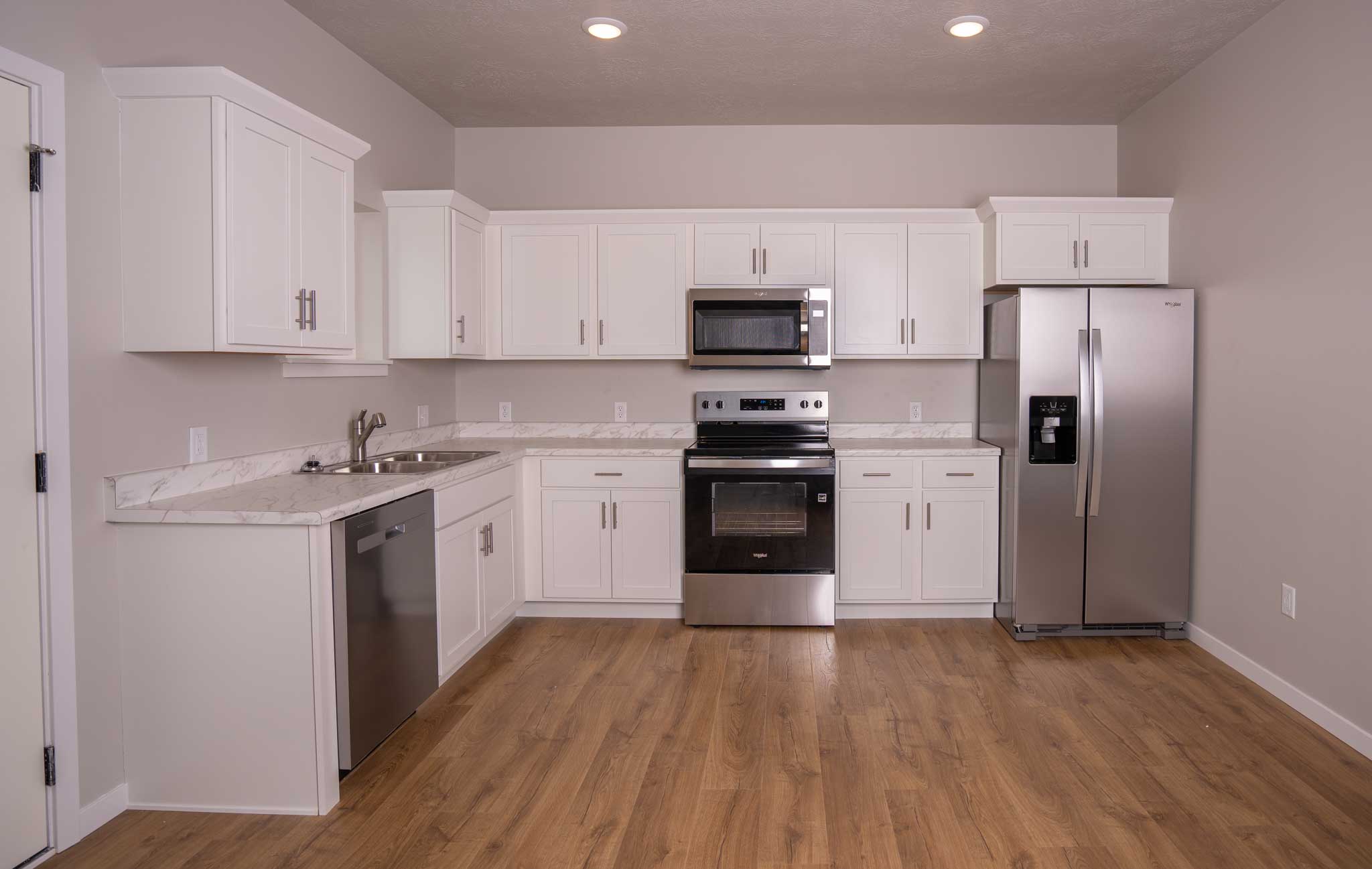 White kitchen cabinets with stainless steel appliances.
