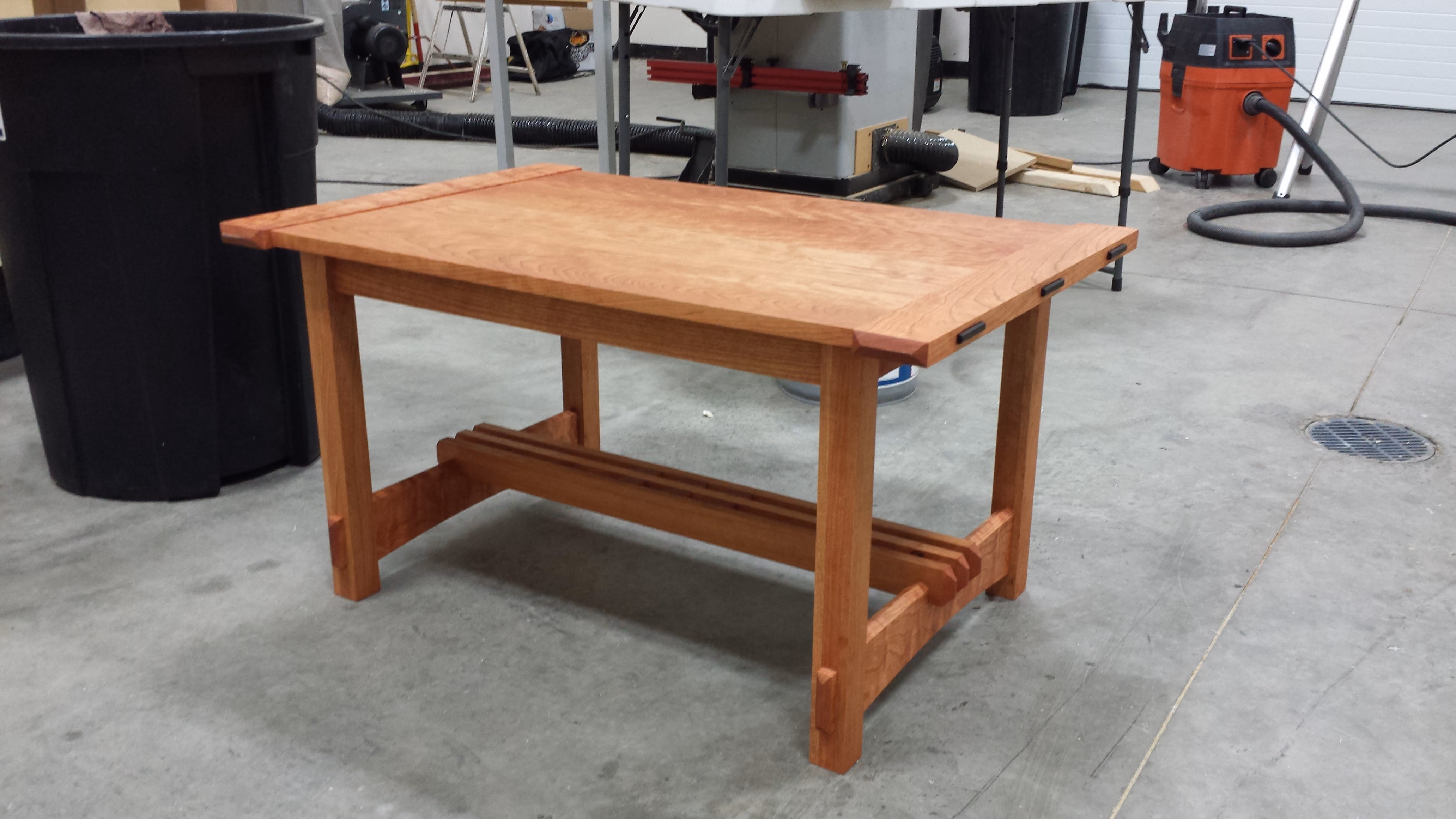 Solid hardwood trestle table with breadboard ends and through-tenon stretchers, built in our Brandon, SD shop