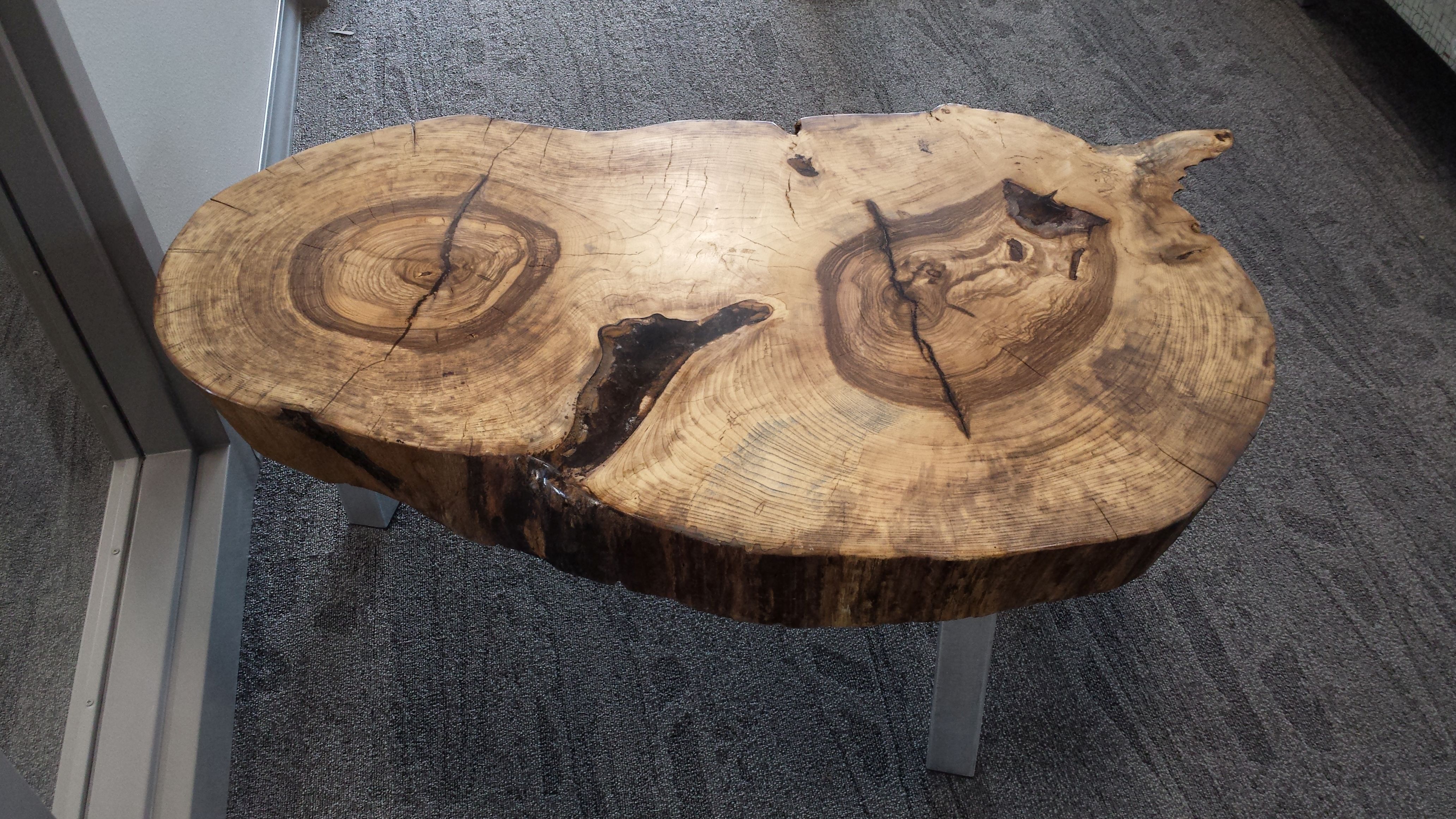 Live-edge round slab coffee table with natural bark edge and visible growth rings, by OdeCo Custom Furniture