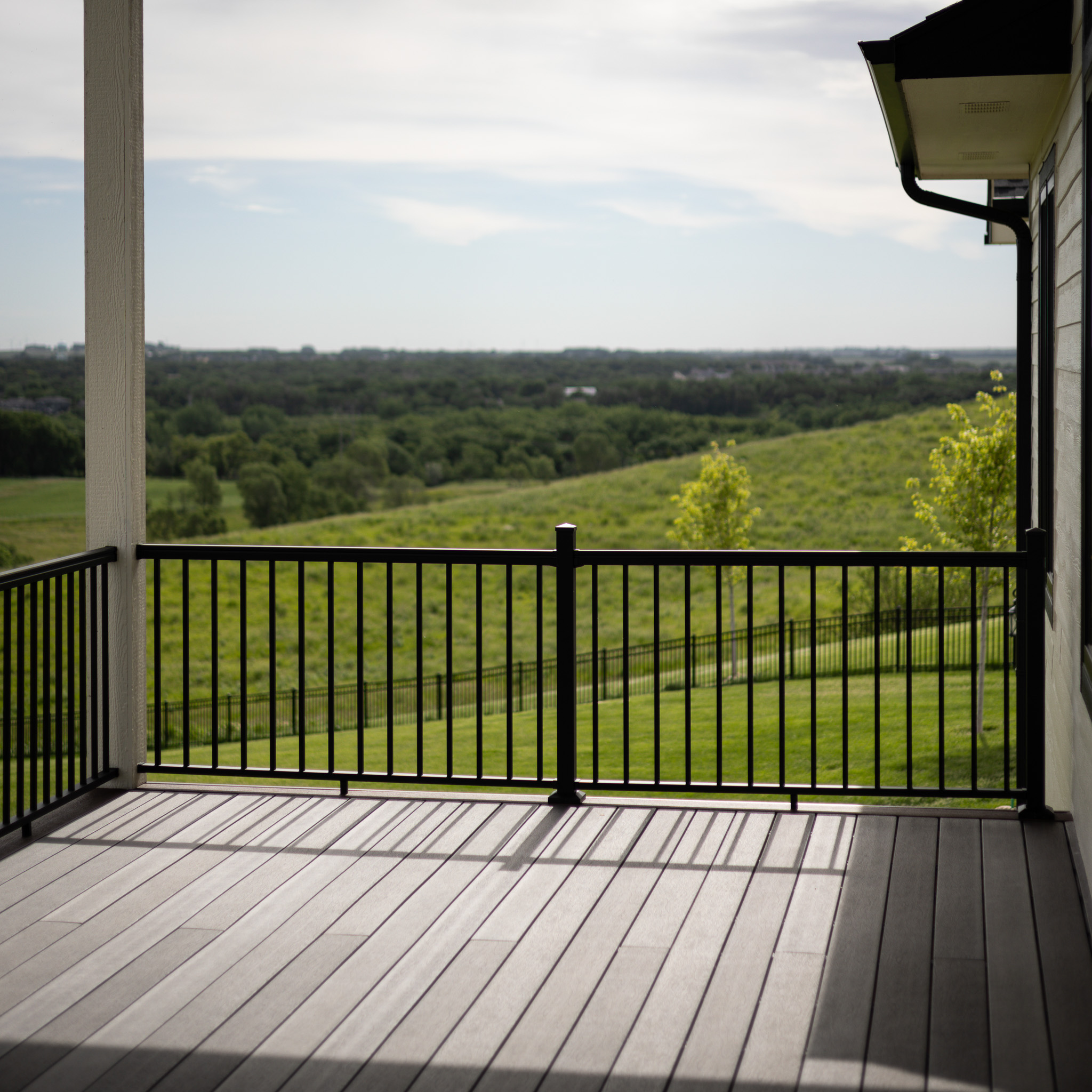 Gray deck with a black metal railing.