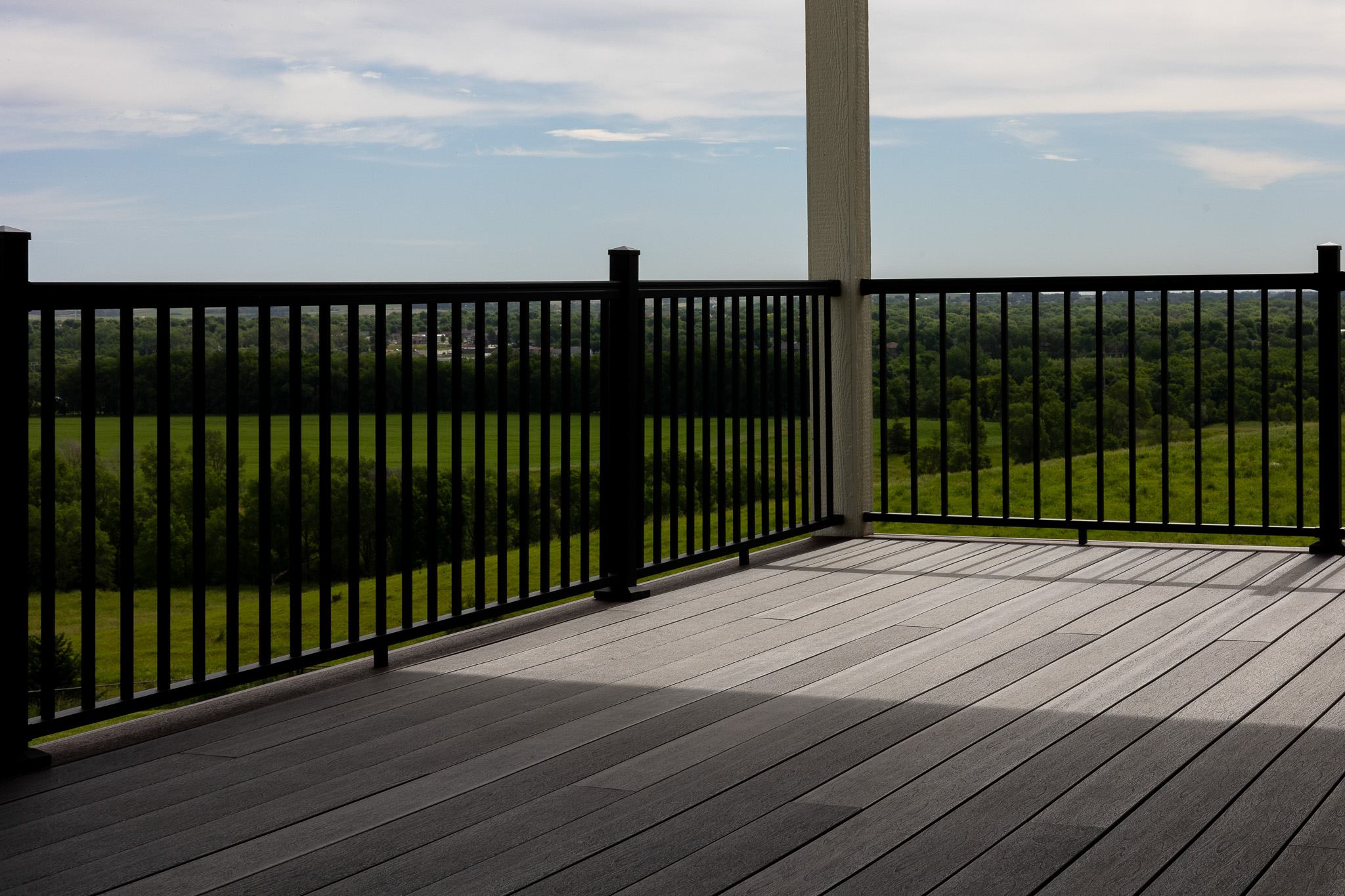 Gray deck with a black metal railing.