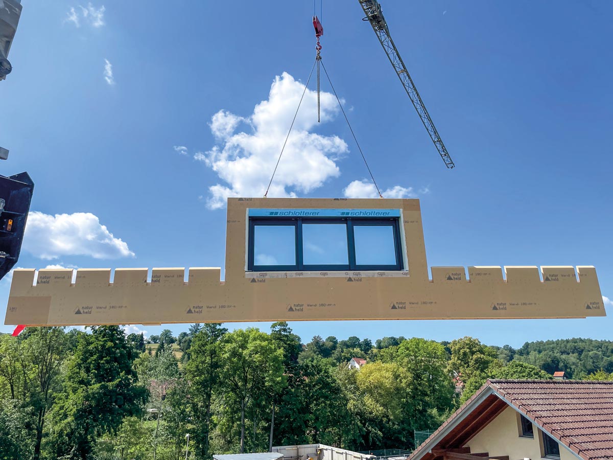 Element für ein Holzhaus befestigt an einem Kran. Holzbau Nüßlein aus Zapfendorf bei Bamberg