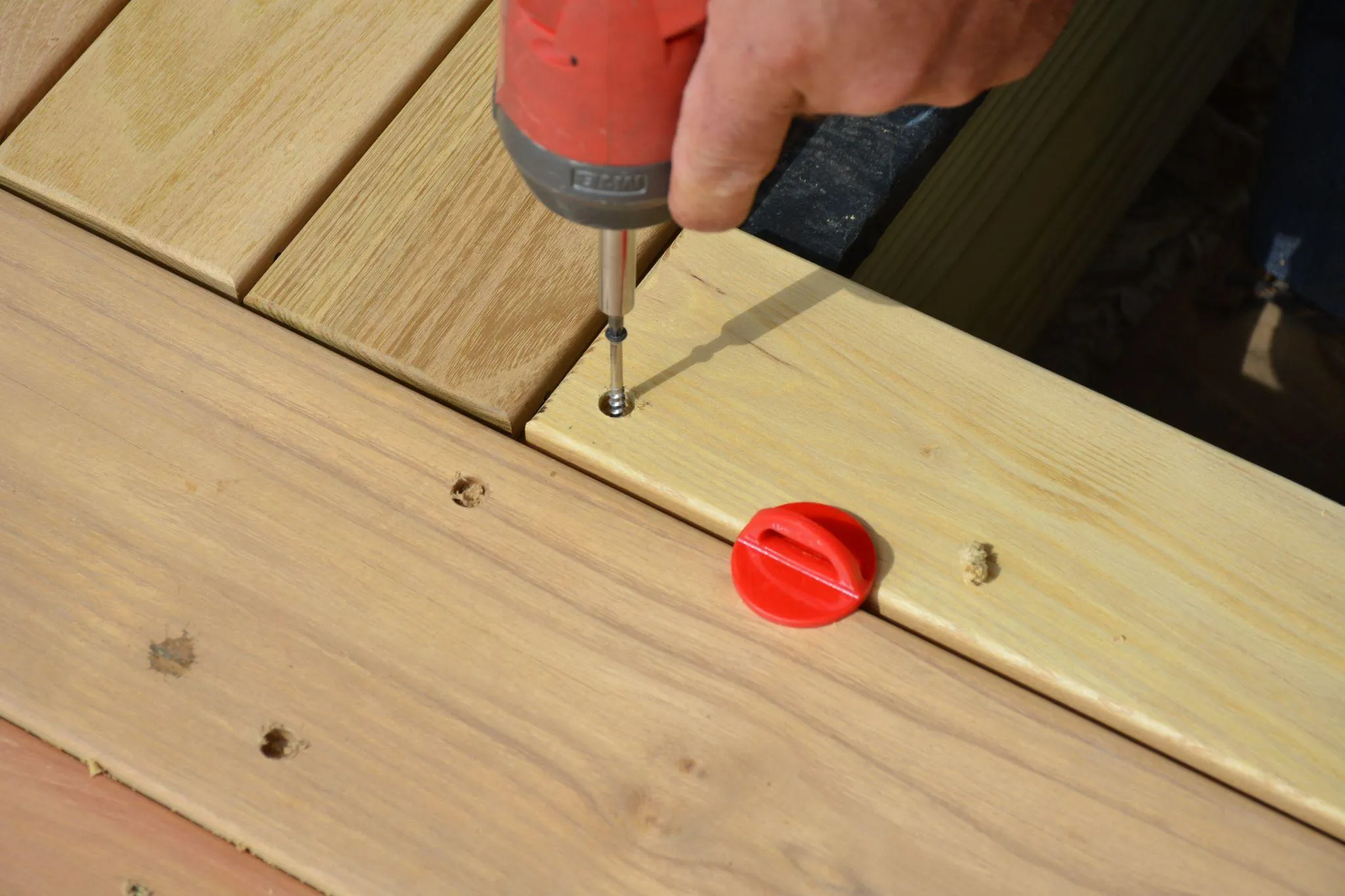 Drill fastening a deck board