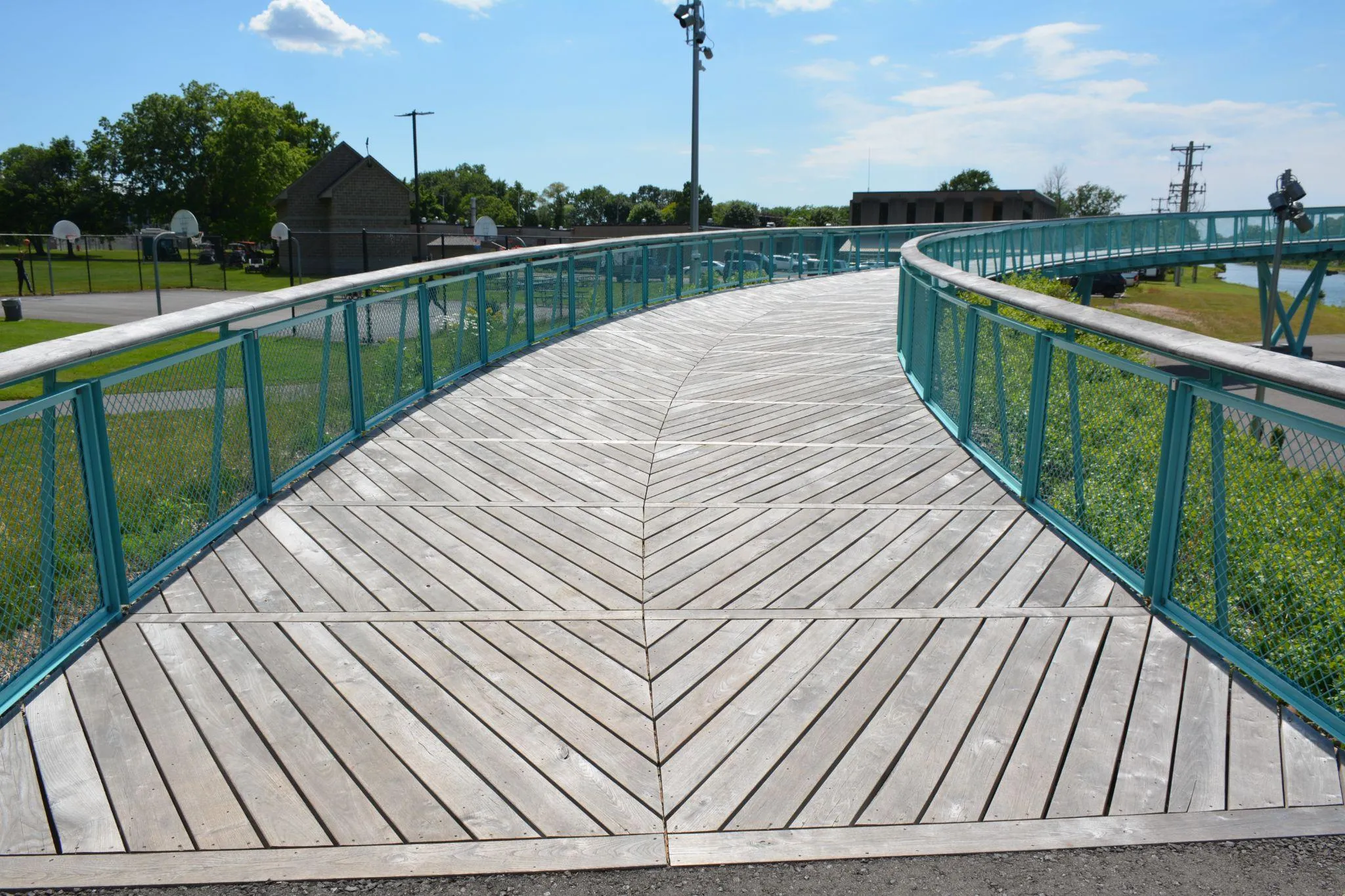Wooden pedestrian bridge with teal railings