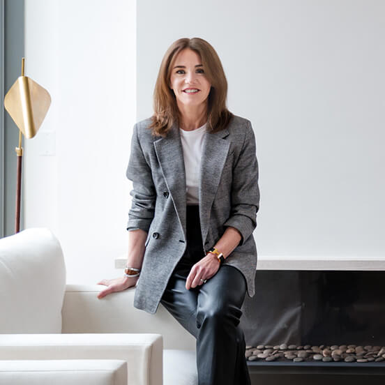 Justine Deluce-Wiley, Chair of the Women’s Health Fundraising Committee, seated on a white sofa.