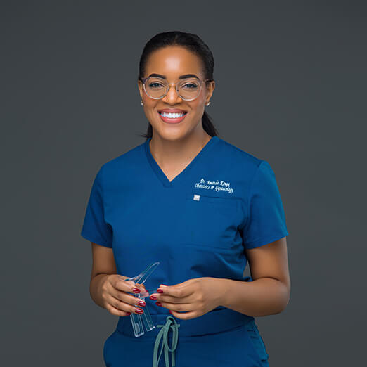 woman wearing blue scrubs and glasses